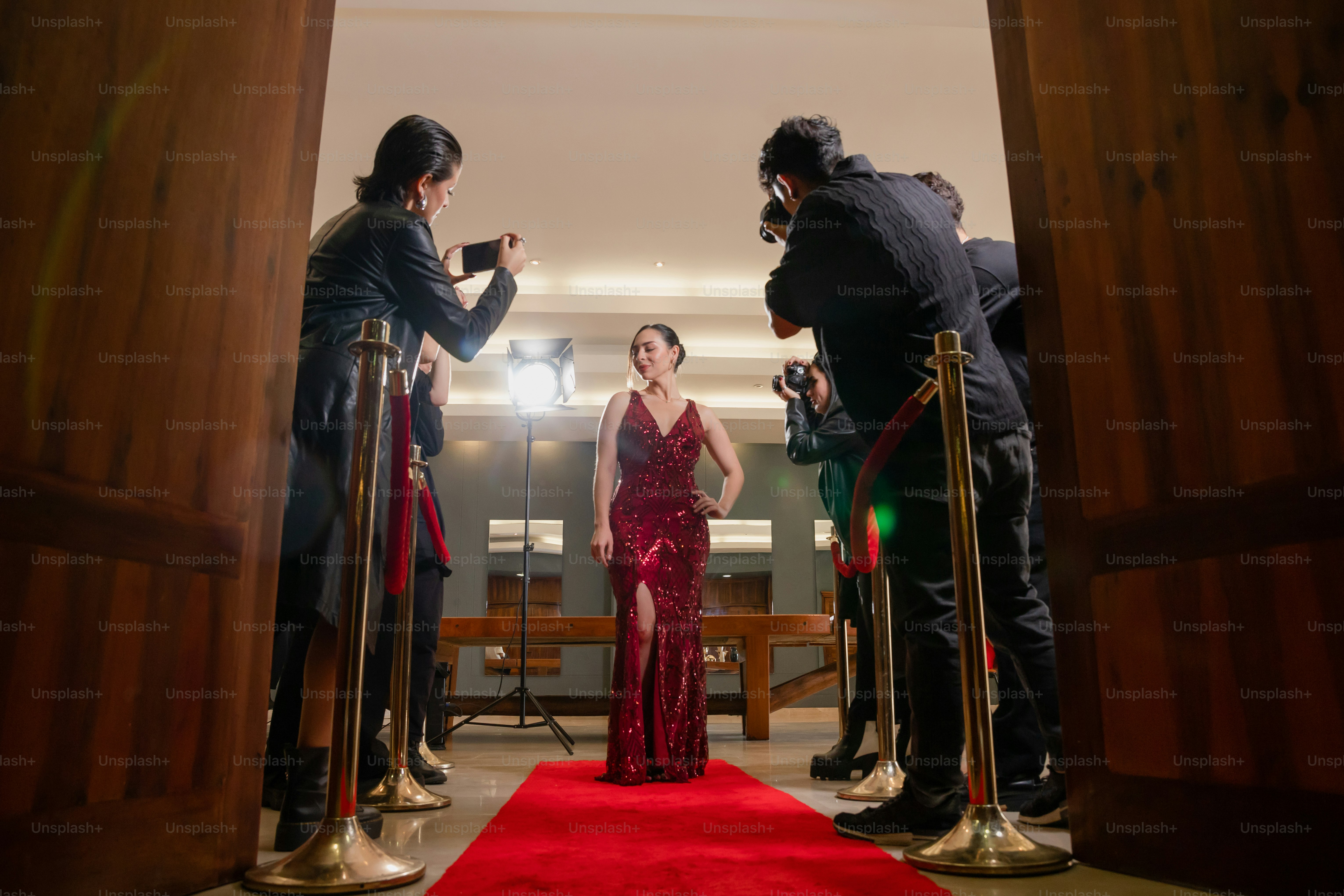 A woman in a red dress standing on a red carpet